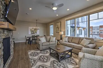 a living room with a couch and a fireplace at Newly Built Ski Condo with Hot Tub and Shuttle Access! in Winter Park