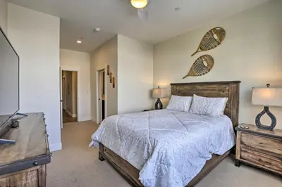 a bedroom with a bed and a dresser and a television at Newly Built Ski Condo with Hot Tub and Shuttle Access! in Winter Park