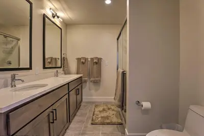 a bathroom with a sink and a toilet and a mirror at Newly Built Ski Condo with Hot Tub and Shuttle Access! in Winter Park