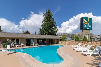 a swimming pool with chairs and a hotel sign at Quality Inn near Rocky Mountain National Park in Estes Park