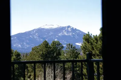 a view of a snow covered mountain from a window at Quality Inn near Rocky Mountain National Park in Estes Park