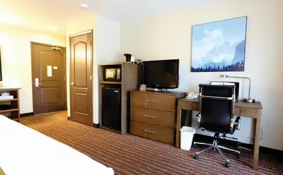 a hotel room with a bed and a desk and a television at Quality Inn near Rocky Mountain National Park in Estes Park