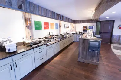 a large kitchen with white cabinets and wooden floors at Quality Inn near Rocky Mountain National Park in Estes Park