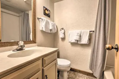 a bathroom with a sink and a toilet and a mirror at Mtn Views and Hot Tub Access Lake Dillon Retreat in Dillon