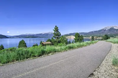 a road next to a lake with mountains in the background at Mtn Views and Hot Tub Access Lake Dillon Retreat in Dillon