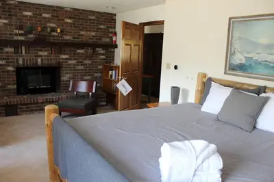 a bedroom with a large bed and a fireplace at Casa Colo in Fraser