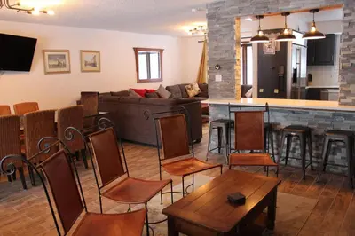 a living room with a couch and a bar with chairs at Casa Colo in Fraser