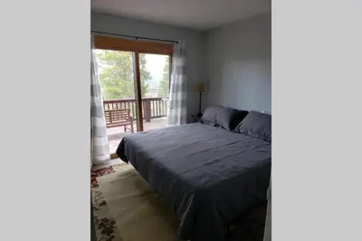 a bedroom with a bed and a balcony at Casa Vista Granby in Granby