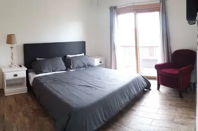 a bedroom with a bed and a chair and a window at Casa Vista Granby in Granby