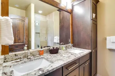 a bathroom with two sinks and a large mirror at Frisco Condo with Rooftop Deck Walk to Main St! in Frisco