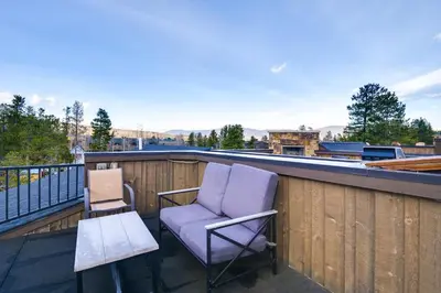 a balcony with a chair and a table and a laptop at Frisco Condo with Rooftop Deck Walk to Main St! in Frisco
