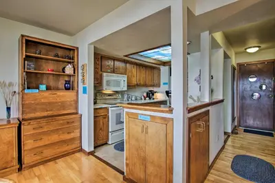 a kitchen with wooden cabinets and a stove top oven at Lakefront Fort Collins Townhome, Only 3 Mi to CSU! in Fort Collins