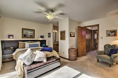 a bedroom with a bed and a couch and a fan at Lakefront Fort Collins Townhome, Only 3 Mi to CSU! in Fort Collins