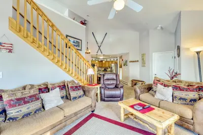 a living room with two couches and a staircase at Revett Retreat in Breckenridge