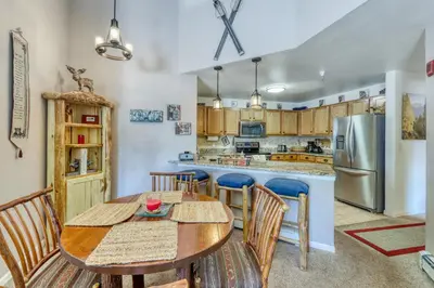 a kitchen with a table and chairs and a refrigerator at Revett Retreat in Breckenridge