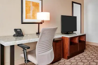 a hotel room with a desk with a television and a chair at Denver Marriott Westminster in Westminster