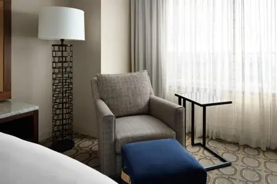 a room with a chair and a table and a window at Denver Marriott Westminster in Westminster