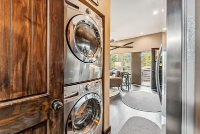 a laundry room with three washer and dryer at Treehouse 1BR with Hot Tub home in Black Hawk