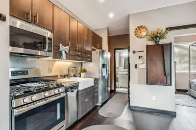 a kitchen with stainless steel appliances and wooden cabinets at Treehouse 1BR with Hot Tub home in Black Hawk