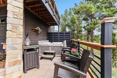 a patio with chairs and a table and a grill at Treehouse 1BR with Hot Tub home in Black Hawk