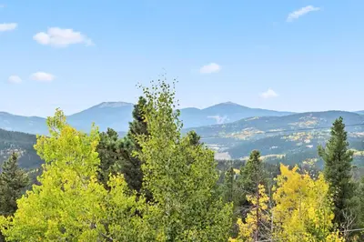 a view of trees and mountains in the distance at Treehouse 1BR with Hot Tub home in Black Hawk