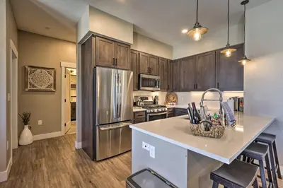 a kitchen with wooden cabinets and a counter top at Condo with View - 1 Block to Main St - 4 Mi to Ski! in Winter Park