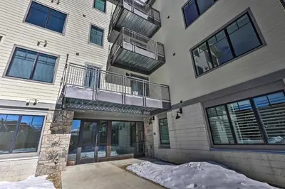 an apartment building with snow in front of it at Condo with View - 1 Block to Main St - 4 Mi to Ski! in Winter Park