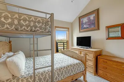 a bedroom with a bunk bed and a television at Snowdance Manor 403 in Keystone
