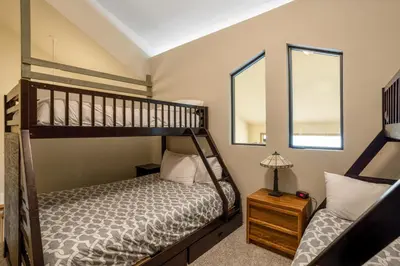 a bedroom with a bunk bed and two windows at Snowdance Manor 403 in Keystone