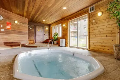 a jacuzzi tub in a room with wooden walls at Snowdance Manor 403 in Keystone