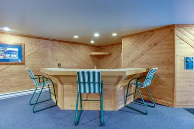 a room with a wooden wall with chairs and a table at Snowdance Manor 403 in Keystone