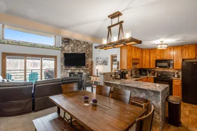 a kitchen and living room with a wooden table at Snowdance Manor 403 in Keystone