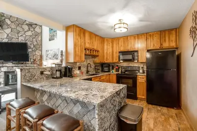 a kitchen with a granite counter top and wooden cabinets at Snowdance Manor 403 in Keystone