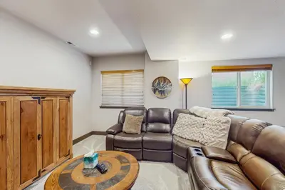 a living room with a leather couch and a table at Tall Timber Getaway in Granby
