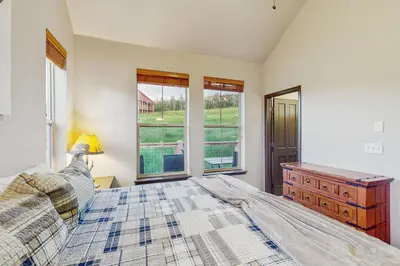 a bedroom with a bed and a dresser and a window at Tall Timber Getaway in Granby