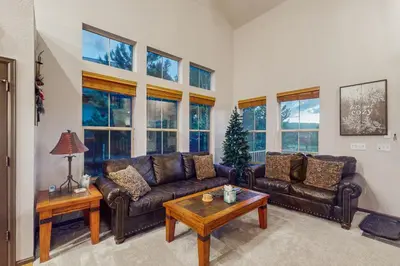 a living room with leather couches and a christmas tree at Tall Timber Getaway in Granby