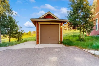 a garage with a brown door on a driveway at Tall Timber Getaway in Granby
