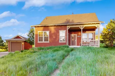 a small house on a grassy hill at Tall Timber Getaway in Granby