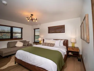 a bedroom with a large bed and a couch at Chic Retreat – Indoor/Outdoor Fireplace, Private Jacuzzi, Great Location! in Estes Park