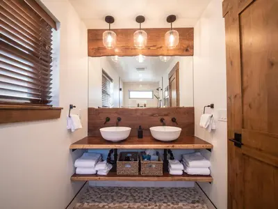 a bathroom with two sinks and a mirror at Chic Retreat – Indoor/Outdoor Fireplace, Private Jacuzzi, Great Location! in Estes Park