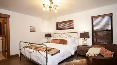a bedroom with a bed and a couch at Blissful Mountain Getaway – Steps to Lake Estes, Indoor/Outdoor Fireplace in Estes Park