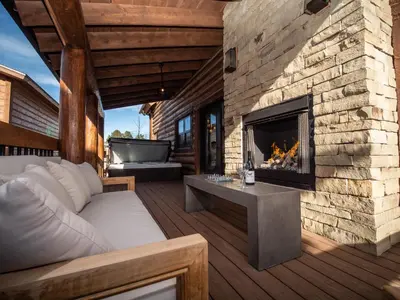 a patio with a fireplace and a couch at Blissful Mountain Getaway – Steps to Lake Estes, Indoor/Outdoor Fireplace in Estes Park