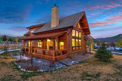 a large wooden house with a roof at The Bear's Getaway - Jacuzzi, Indoor/Outdoor Fireplace, Fantastic Location! in Estes Park