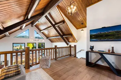 a living room with wooden ceilings and a large tv at Relax in The Rockies – Located on Lake Estes, Jacuzzi and Indoor/Outdoor Fireplace in Estes Park