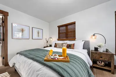 a bedroom with a bed with a tray of food on it at Relax in The Rockies – Located on Lake Estes, Jacuzzi and Indoor/Outdoor Fireplace in Estes Park
