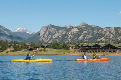 three people in kayaks on a lake with mountains at Relax in The Rockies – Located on Lake Estes, Jacuzzi and Indoor/Outdoor Fireplace in Estes Park