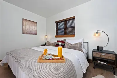 a bedroom with a bed with a tray of food on it at Cozy & Relaxing – Indoor/Outdoor Fireplace, Jacuzzi and BBQ grill in Estes Park