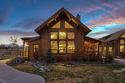 a home with a large window and a house at Cozy & Relaxing – Indoor/Outdoor Fireplace, Jacuzzi and BBQ grill in Estes Park