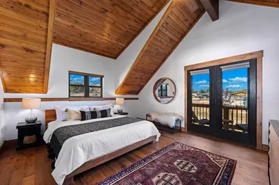 a bedroom with a large bed and a large window at Fly Rod Inn – Two Large Patios, Jacuzzi and Indoor/Outdoor Fireplace in Estes Park