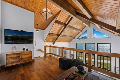 a large living room with wooden ceilings and windows at Fly Rod Inn – Two Large Patios, Jacuzzi and Indoor/Outdoor Fireplace in Estes Park
